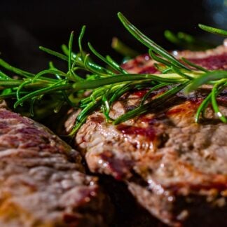 Seared flat iron steaks with fresh rosemary.