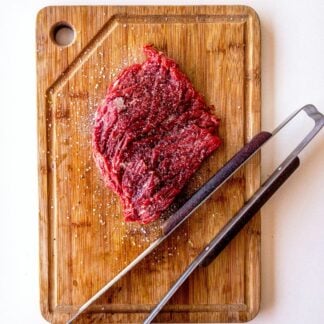 Uncooked flank steak on a cutting board.